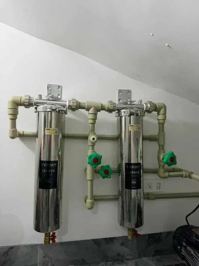 Bộ lọc tổng chung cư lắp trên tường với cụm van khóa và đường ống kỹ thuật